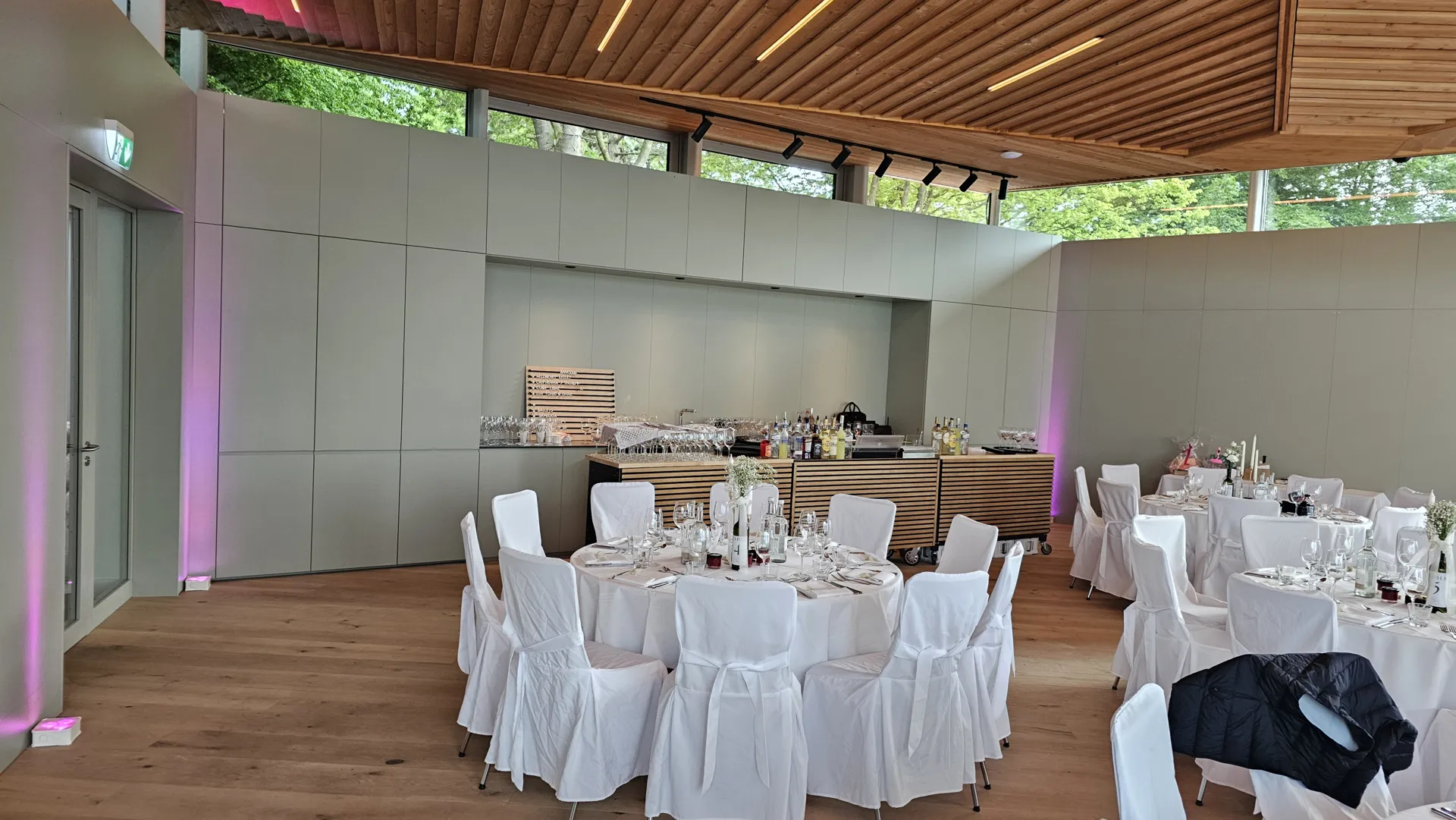 Gedeckte Tafel im hellen Veranstaltungsbereich mit Holzdecke