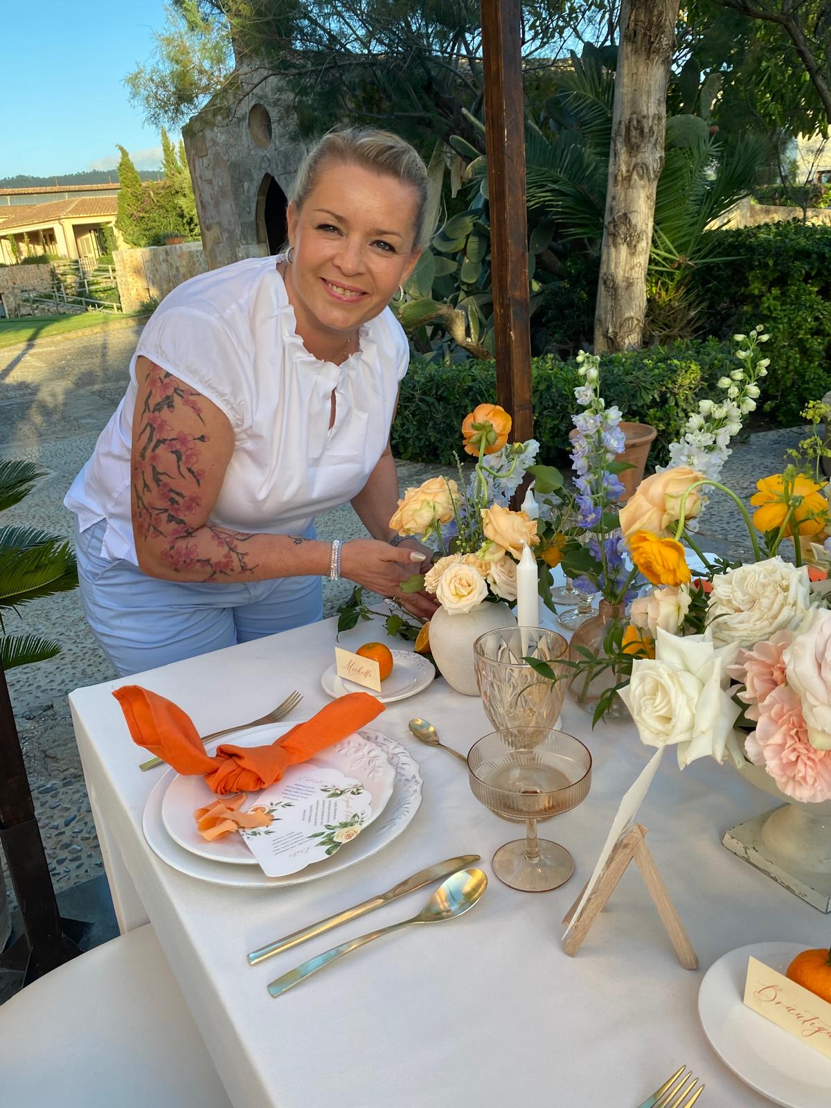 Yvonne Bosse von Sparkling Weddings an einer festlich gedeckten Hochzeitstafel